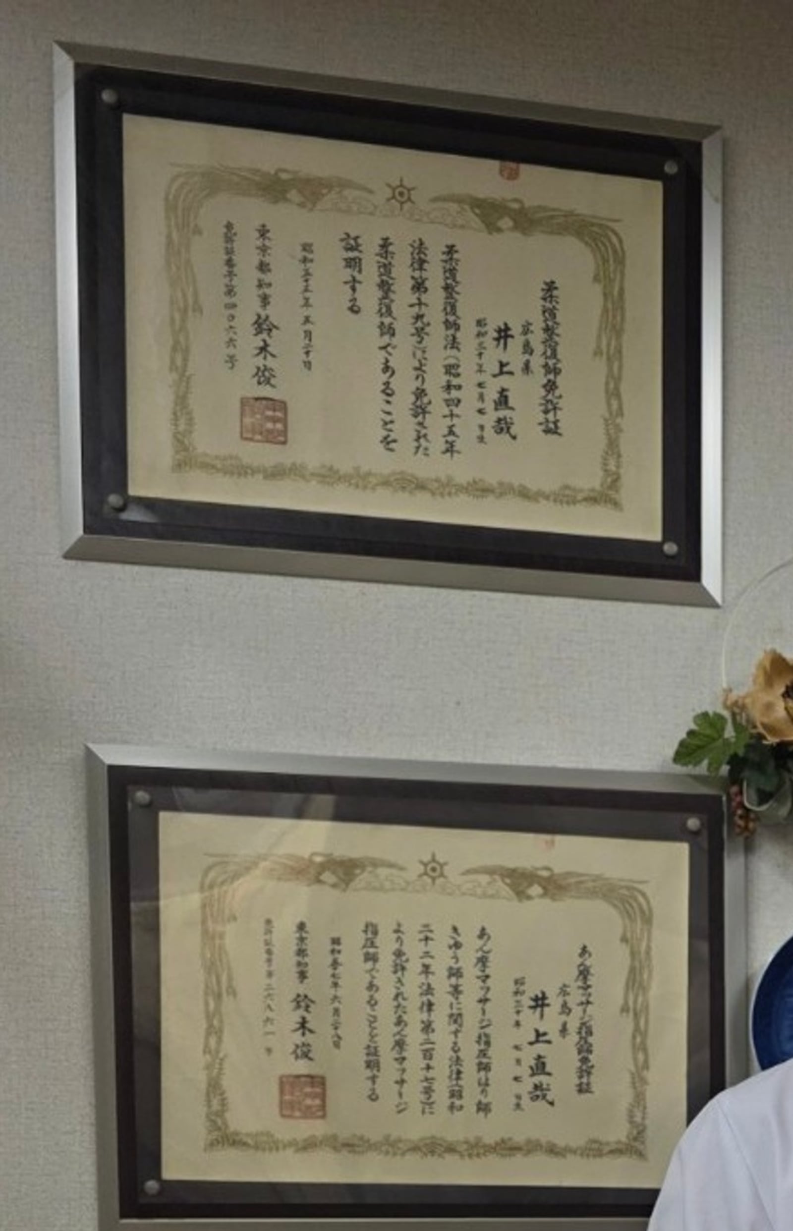 壁に並んで掲示された複数の資格証（柔道整復師免許証・あん摩マッサージ指圧師免許証）